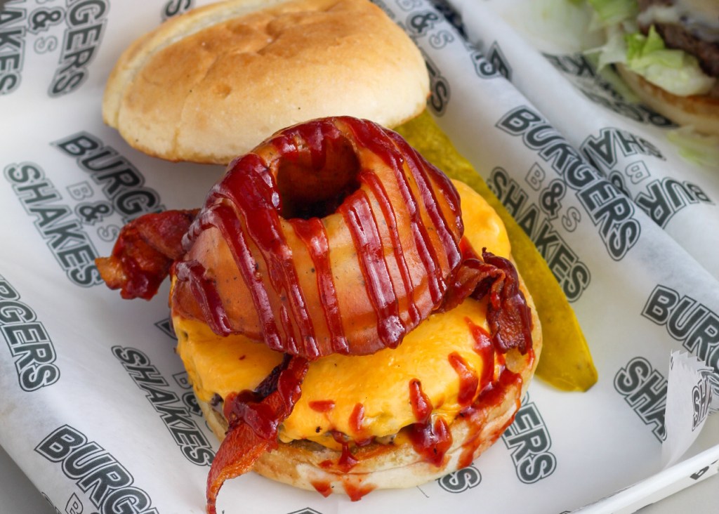 an open-faced cheeseburger with sauces