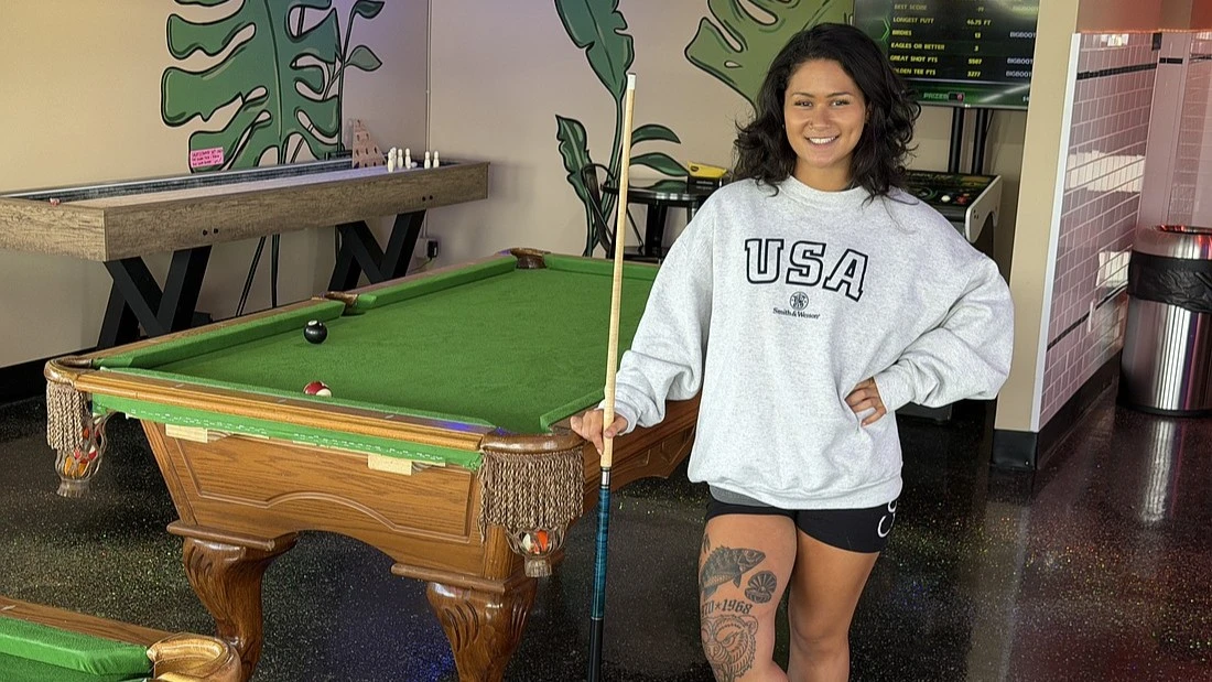 Cianna Bommarito, co-owner of Kava & Co., stands near a pool table inside the business.