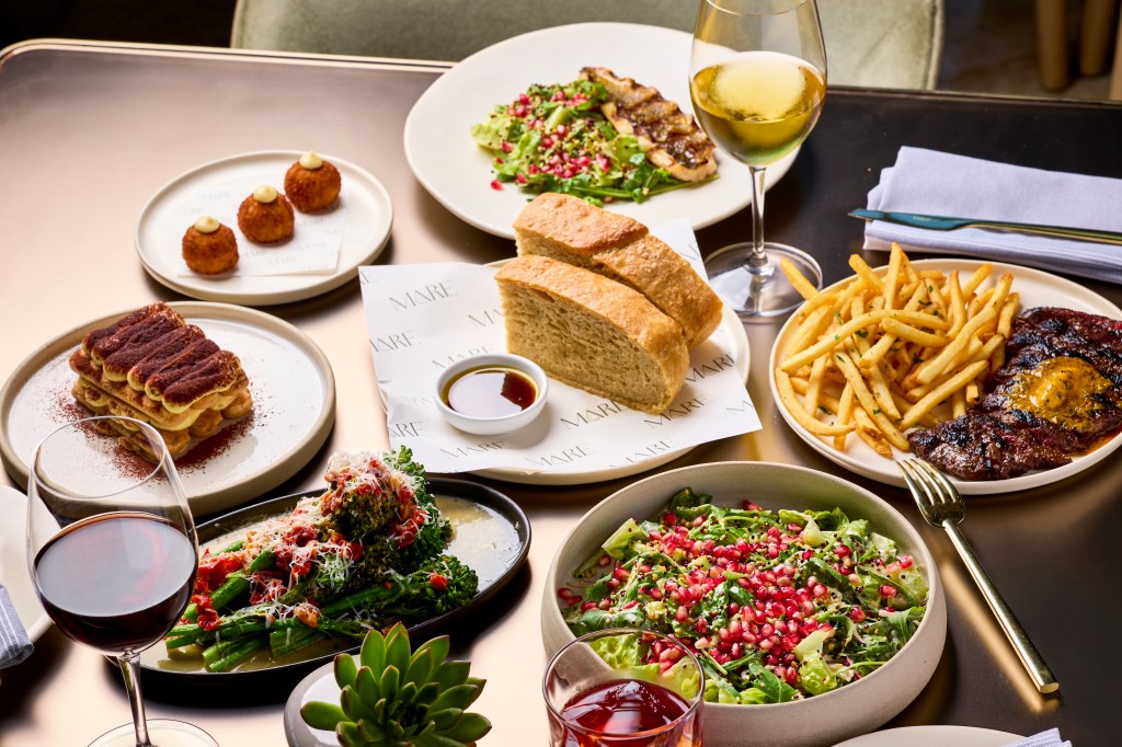 an assortment of platters and dishes of food on a brown table
