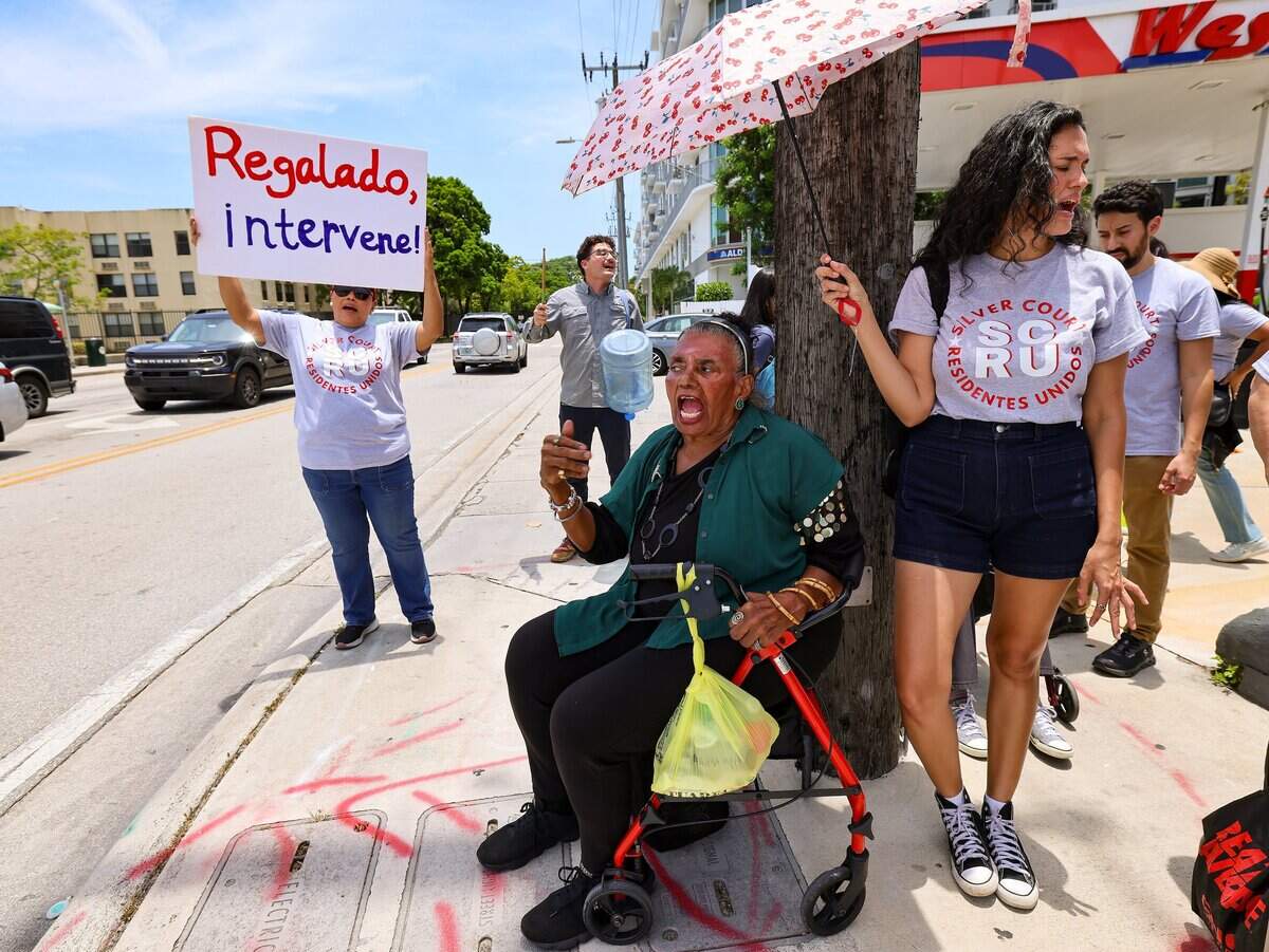 Supporter Juanita Alvarez, center, protests alongside residents at the southeast corner of U.S. 1 and Douglas Road, as residents of Silver Court, a trailer park in Little Havana, face eviction and picket outside the office of Miami-Dade Commissioner Raquel Regalado, urging the county to intervene.