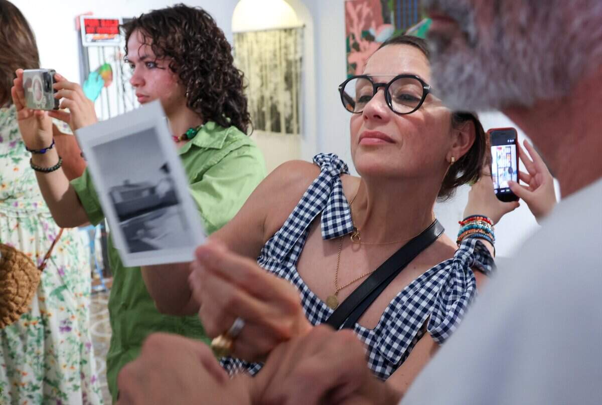 Clem Corugedo, 19, left and her parents Susana Corbett, and Jorge Corugedo, right, explore the artwork “The Weight of Ivory, during “Turn of A Century,” a farewell event inside the 100-year-old home which is scheduled for demolition, on Monday, July 13, 2026, in Miami. Friends - Sophia Corugedo, and Sofia Villalonga, hosted the Turn of a Century event at the 100-year-old home, which is slated for demolition after being sold to a developer. The gathering features artists, performers and dancers saying farewell to the house before the owners move out by July 15.