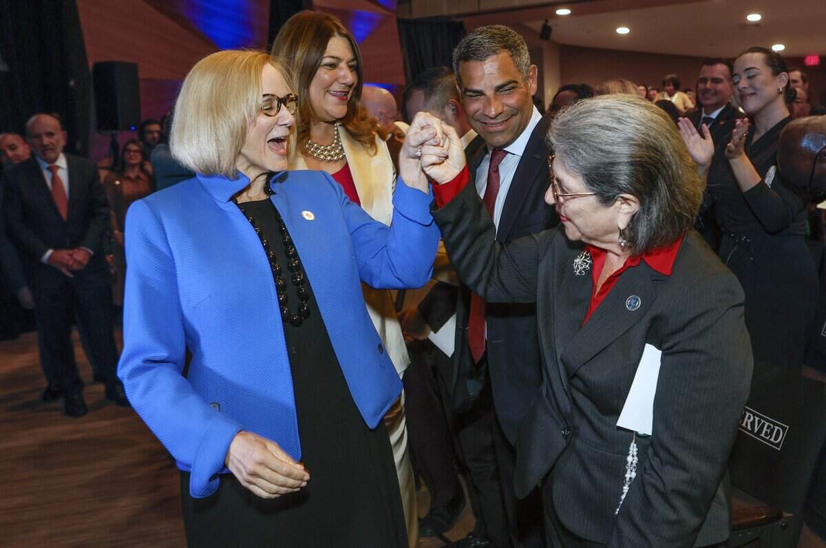City of Miami Mayor Eileen Higgins, at left, is congratulated by Miami-Dade County Mayor Daniella Levine Cava, right, President of Miami Dade College Madeline Pumariega, at top left, and former Miami Mayor Francis Suarez, at top right, after Higgins installation ceremony at the Miami-Dade College Wolfson Campus Auditorium in Miami, Florida, on Thursday, December 18, 2025.
