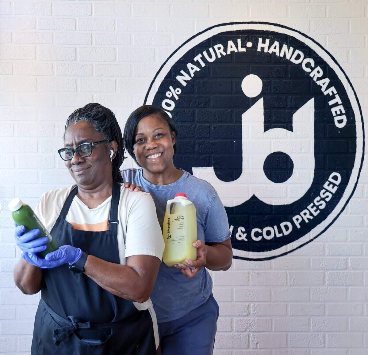 Inventory specialist Mae Mike, left, and her niece, Fathiyyah “Tia” Doster, right, owner of JuiceDefined, are photographed with natural juices at their Opa-locka juice bar, Thursday, July 30, 2026, in downtown Opa-locka, Fla.