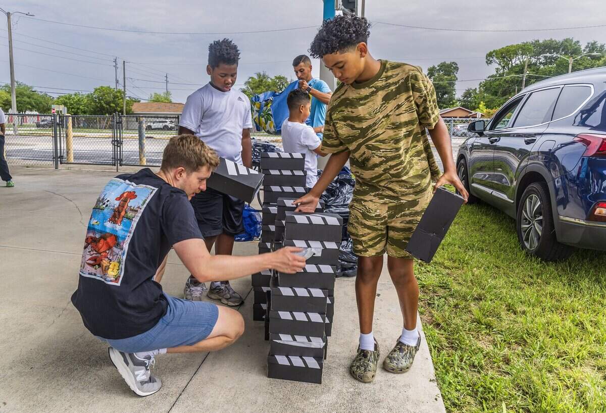 Volunteer Nicholas Uvanovic, with Miami Scores, checks out shoe boxes with Za'ryan Robinson (center) and Juelz Quinn, before been handed out to students from different Miami Dade schools selected to serve as player escorts during the 2026 FIFA World Cup, quarter-final game between England and Norway as Miami Scores program was selected to be part of the FIFA World Cup 26 Player Escort Program, on Saturday July 11, 2026.