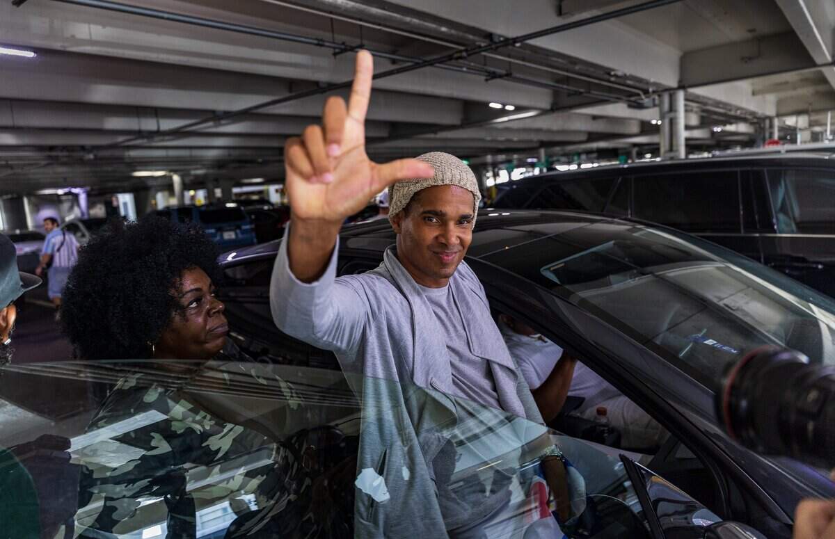 Cuban dissident artist Luis Manuel Otero Alcántara puts up a “liberty” hand sign after arriving at Miami International Airport on Saturday, July 18, 2026.