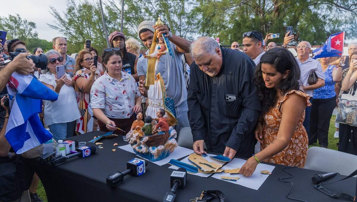 The Rev. José Joaquin Espino joined Salomé García (far left) and Anamely Ramos (far right) in helping Cuban dissident artist Luis Manuel Otero Alcántara piece together an image of the Virgin Mary that he brought from Cuba to Our Lady of Charity National Shrine on Saturday.