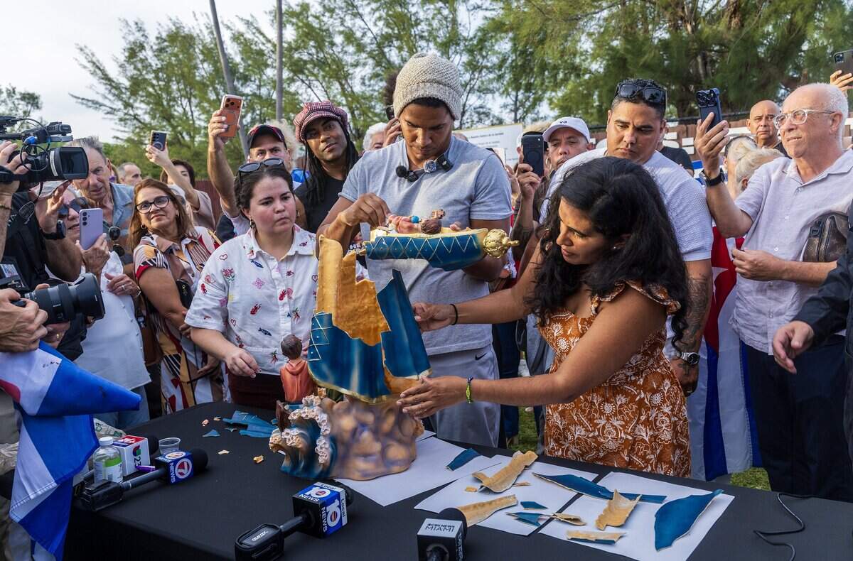 Salomé García (far left) and Anamely Ramos (far right) help Cuban dissident artist Luis Manuel Otero Alcántara piece together a statue of the Virgin Mary that he brought from Cuba at Our Lady of Charity National Shrine on Saturday.