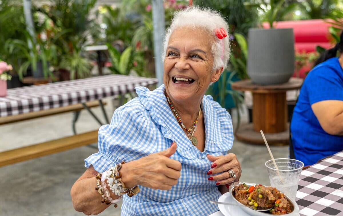 Luz Camacho smiles beside her oxtail meal at Royd's in Miami, Fla., on Sunday, May 31, 2026.