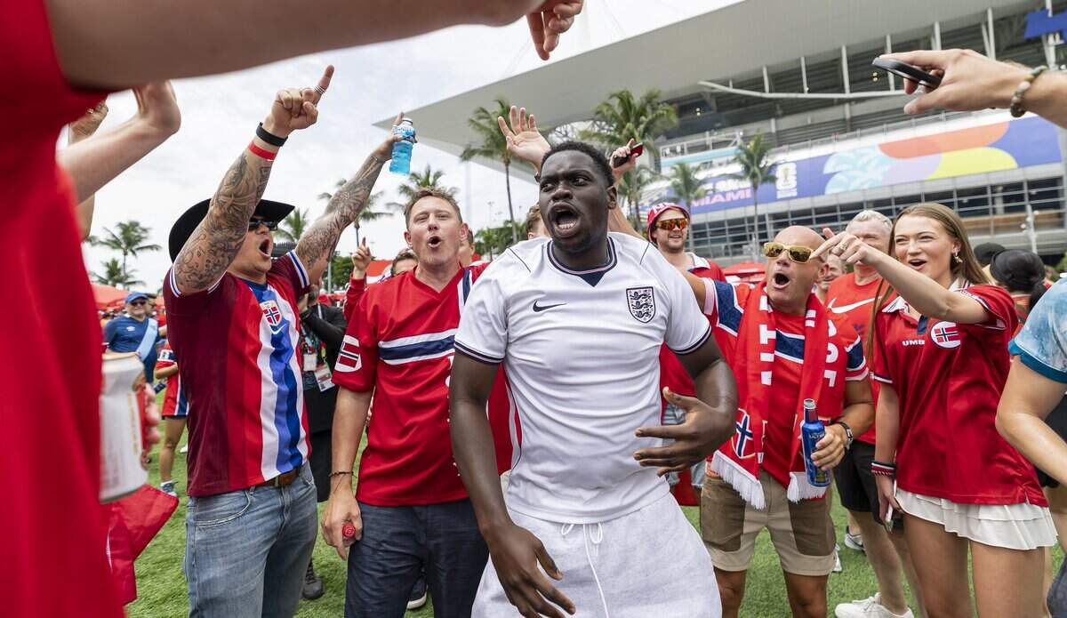 England fan Jensen Adeyanju reacts surrounded by Norway fans as they arrive to watch their teams compete in a FIFA World Cup 2026 Quarter Final soccer match at Hard Rock Stadium (Miami Stadium) on Saturday, July 11, 2026 in Miami Gardens, Fla.