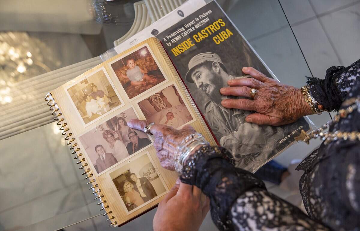 Susie Rosales, 86, and her grandson, Alberto Rosales, 23, look at a photo album at their home on Friday, May 15, 2026, in Miami, Fla.