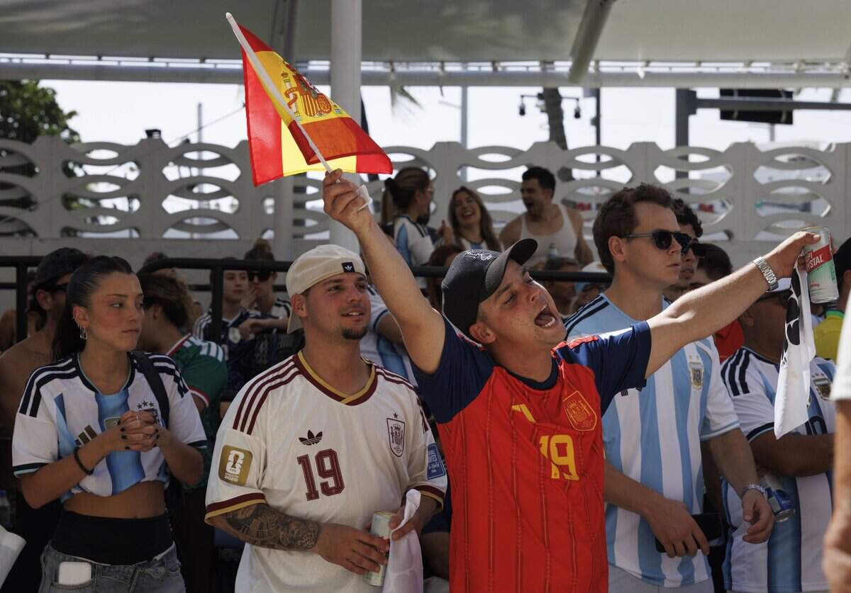 A Spain fan cheers and waves a flag during a watch party for the 2026 FIFA World Cup Final between Argentina and Spain on Sunday, July 19, 2026, at the Miami Beach Bandshell in Miami Beach, Fla. Spain won in extra time.