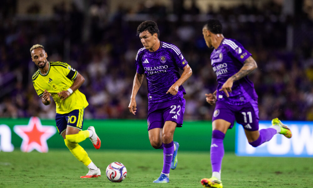 Image of Justin Ellis dribbling the ball with Tiago to his left and Nashville's Hany Mukhtar defending to his right.
