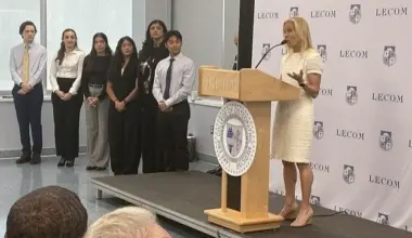 Mayor Donna Deegan stands on a podium addressing the audience at Jacksonville's first medical school.