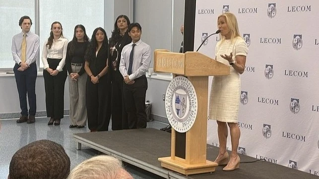 Mayor Donna Deegan stands on a podium addressing the audience at Jacksonville's first medical school.
