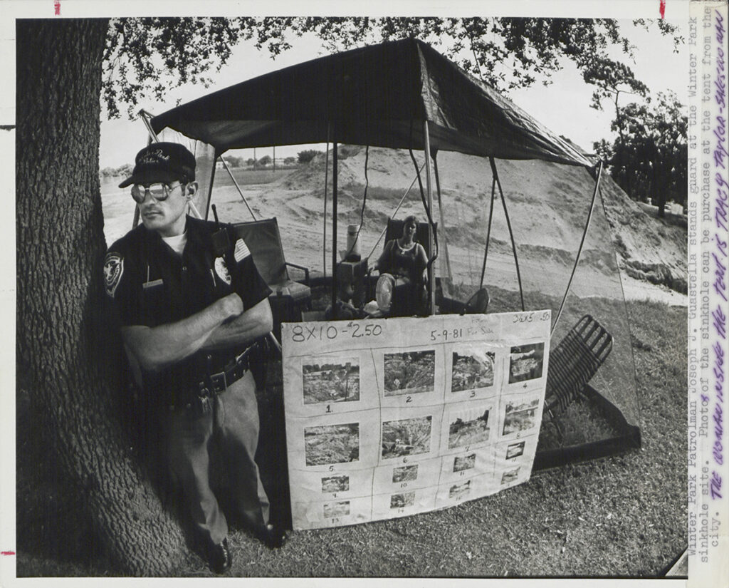 A souvenir stand near the Winter Park sinkhole displays photographs for sale by the City of Winter Park for visitors touring the site.