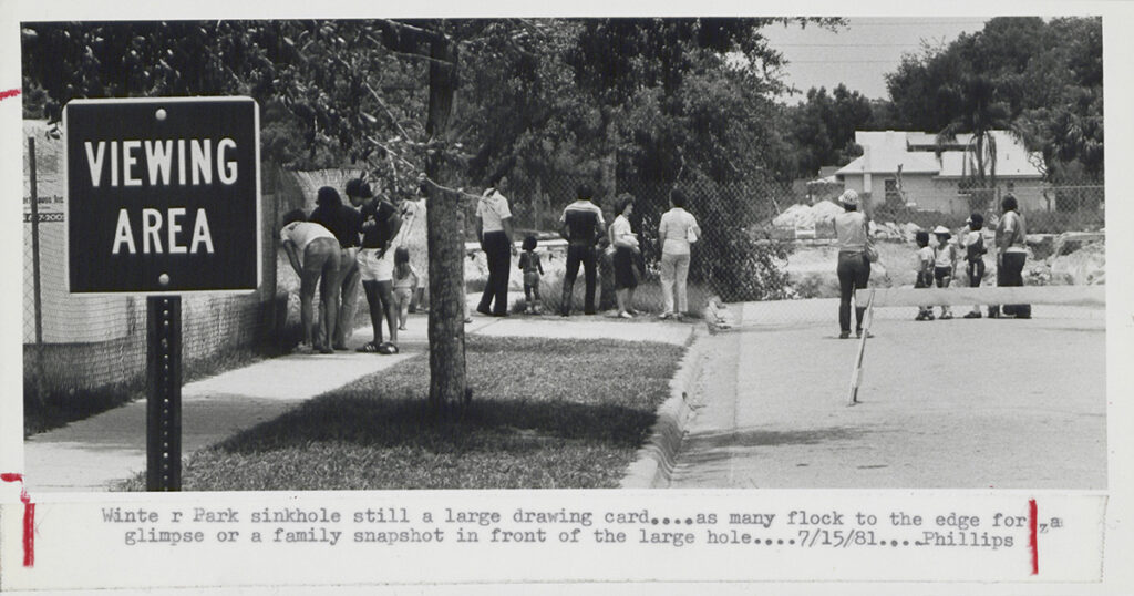 Visitors gather at a designated viewing area near the Winter Park sinkhole in July 1981 after its collapse in May.