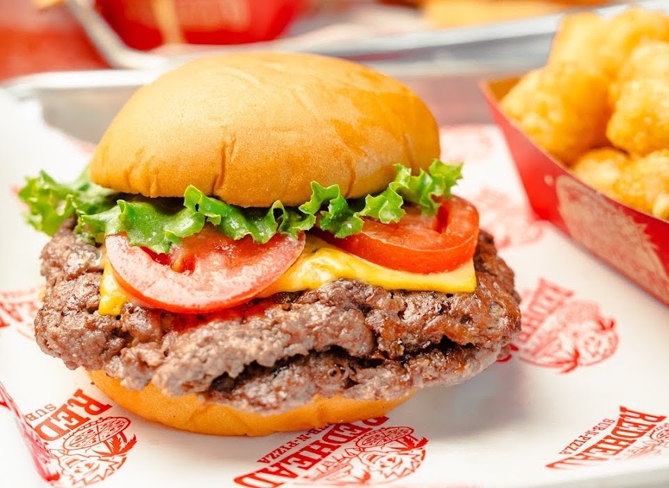 a double cheeseburger with tomatoes and lettuce