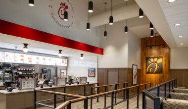 Interior of restaurant with counters, registers, and menu displays.
