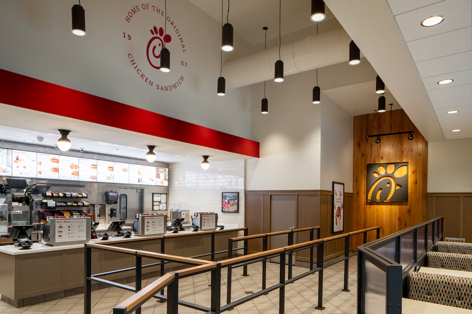 Interior of restaurant with counters, registers, and menu displays.