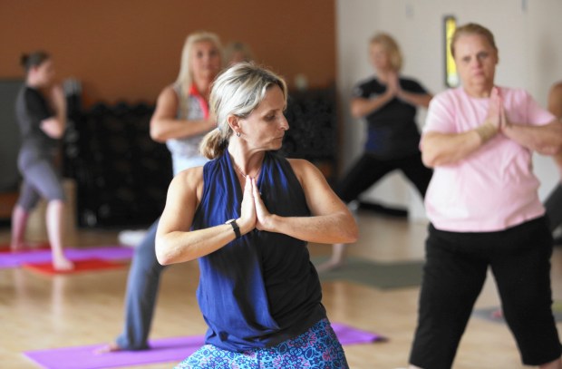 Lindy Moore teaches a yoga class previously. Indoor fitness classes are one way to stay in shape and stay cool during Florida's summer months. (Ricardo Ramirez Buxeda / Orlando Sentinel)