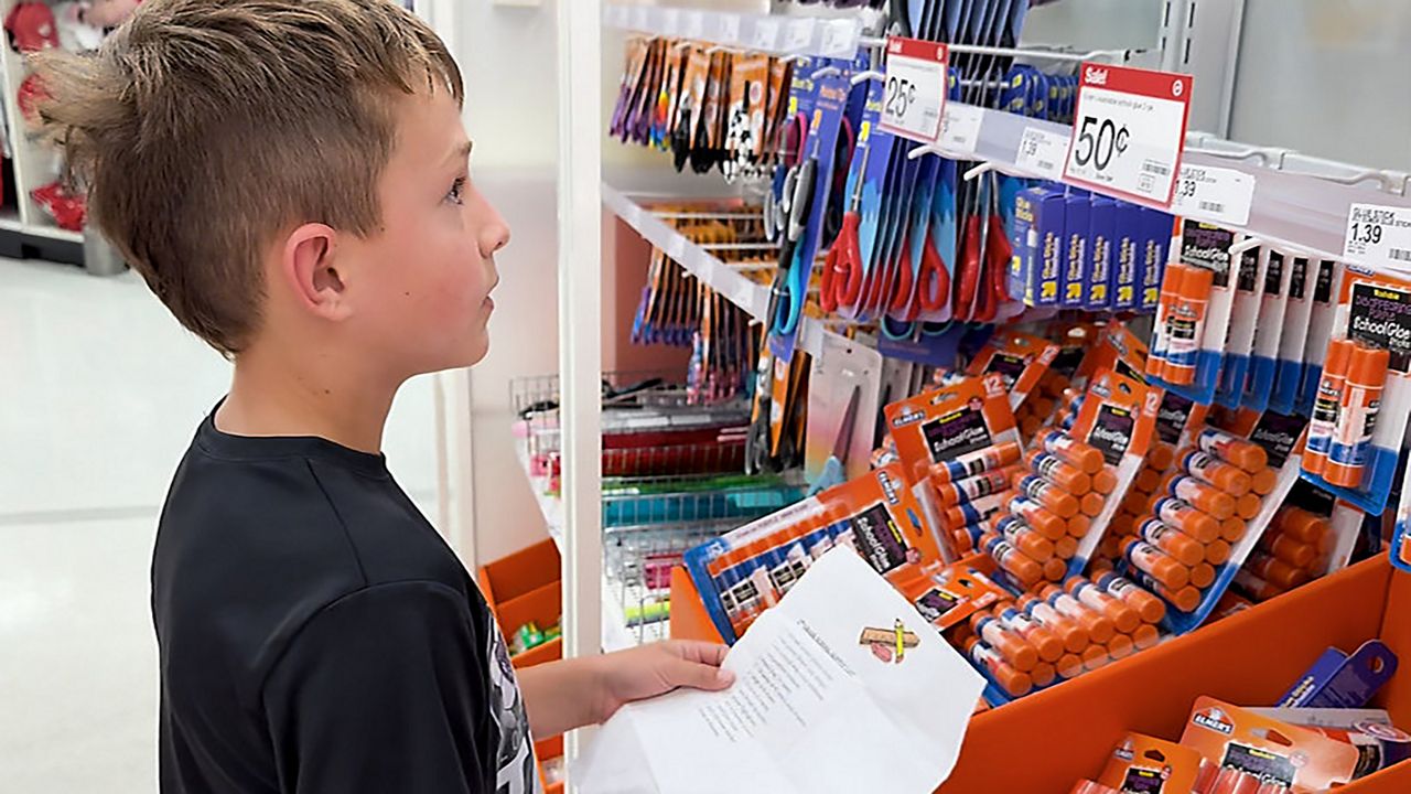 An student looks over a school supply list while shopping for back-to-school items. (Spectrum News 1/Saima Khan)