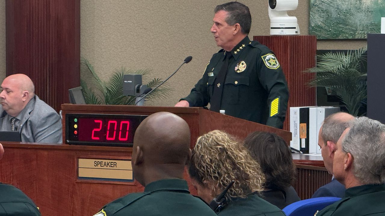 Sheriff John Mina stands at a podium as he reviews his budget request. (Spectrum News/Keith Landry)