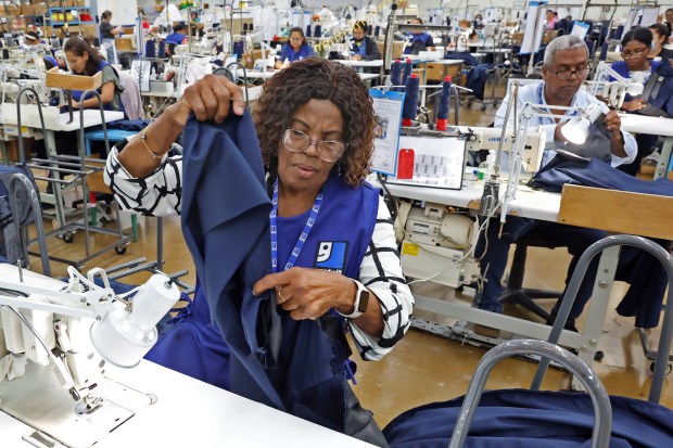 Benite Augustin, of Miramar, sews U.S. Air Force dress slacks at the Goodwill Industries of South Florida headquarters in Miami on Tuesday, June. 30, 2026. (Amy Beth Bennett / South Florida Sun Sentinel)