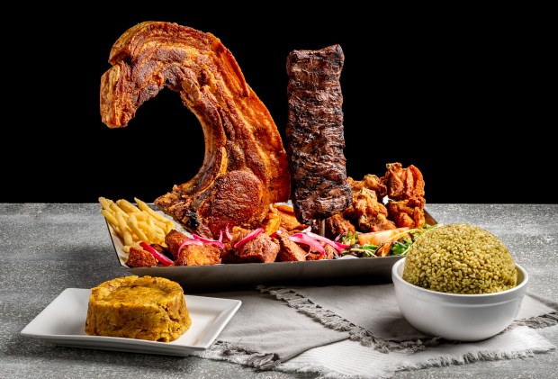 The restaurant features family-style platters like the La Granja Ensalta, which includes Skirt steak, "Kan Kan" Pork chop, fried bone-in Chicken chunks with crackling, fried Pork chunks, cilantro rice, french fries, tostones, and one order of mashed green plantains and green salad (Courtesy of El Cilantrillo)