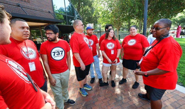 Members of the Orlando chapter of the Unite Here union listen to community canvaser Diego Henry, Jr., right, as they gather in from of the Orange County Administration building ahead of the first meeting of the 2026 Orange County Tourist Development Tax Citizen Advisory Task Force, Tuesday, July 21, 2026. (Joe Burbank/Orlando Sentinel)