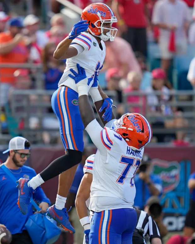 Florida two-year starting guard Knijeah Harris (right) hopes to celebrate more scoring with the Gators in 2026. Shown here hoisting receiver Aidan Mizell in the air after his touchdown Nov. 2, 2024 against Georgia in Jacksonville. (AP Photo/John Raoux)