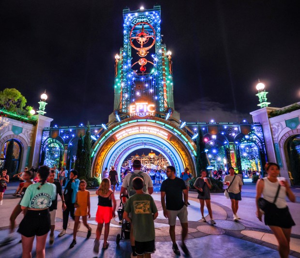 Guests watch the debut of the first nighttime finale fireworks show at Universal Epic Universe in Orlando, Tuesday, July 7, 2026. With the Helios Grand Hotel as a backdrop, the "Universal Celestial Goodnight" show launches at Cosmos Lagoon and features a highly synchronized production of dancing water fountains and light with music and fireworks. (Joe Burbank/Orlando Sentinel)