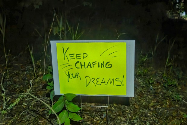 A funny sign encourages runners during the Skunk Ape Night Run in Green Swamp on July 18, 2026. (Patrick Connolly/Orlando Sentinel)