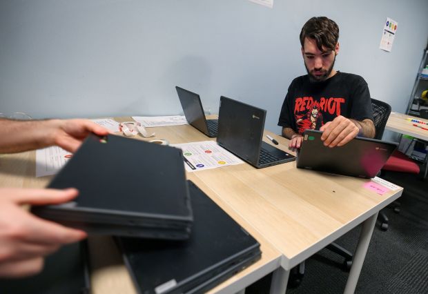 Techtonic apprentice Isaiah Garcia assesses the condition of used Chromebooks at the company's Winter Park headquarters, Monday, July 27, 2026. Techtonic is a division of the Jonathan's Landing Foundation that trains neurodivergent employees to become certified IT technicians. (Joe Burbank/Orlando Sentinel)