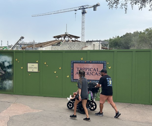 Disney's Animal Kingdom visitors walk past the construction site for a new Tropical Americas land set to open in 2027 at the theme park. The area previously was known as Dinoland U.S.A., an opening-day attraction. (Dewayne Bevil/Orlando Sentinel)