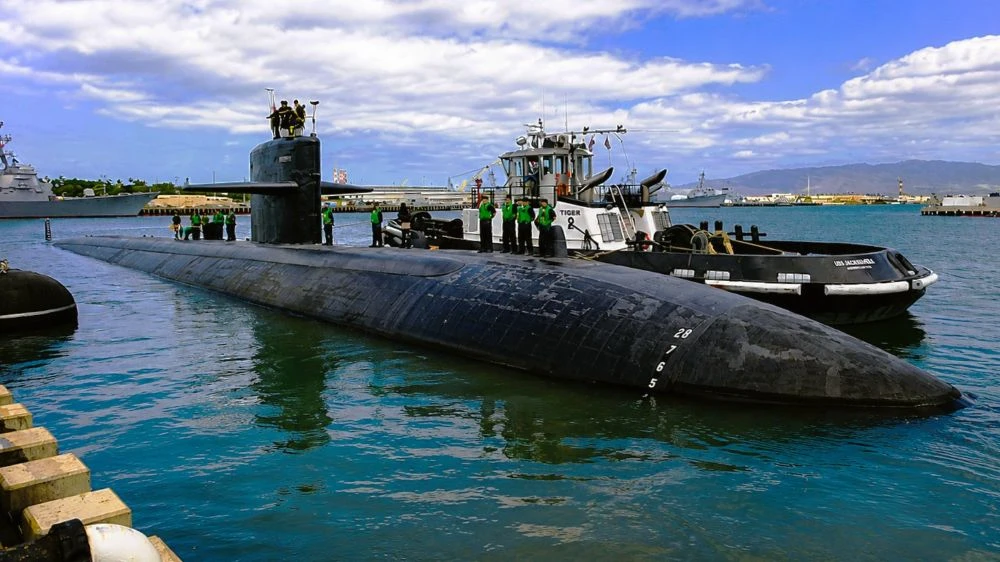 Sailors stand atop the USS Jacksonville submarine.