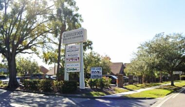 Entrance sign for Carrollwood Village Shoppes retail center in Tampa with tenant listings.
