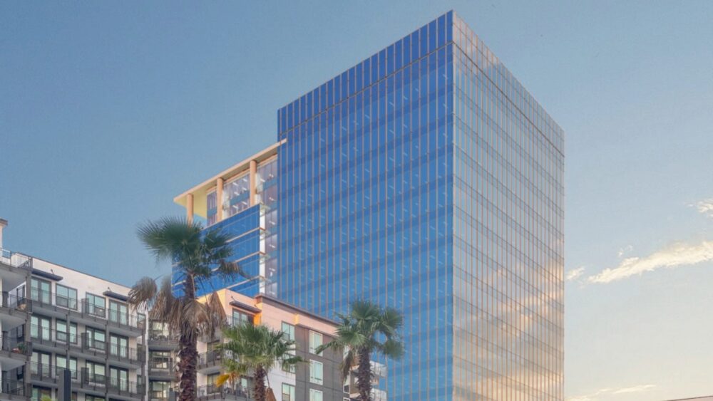 Midtown East’s glass office tower rises above apartments and palm trees at Midtown Tampa.