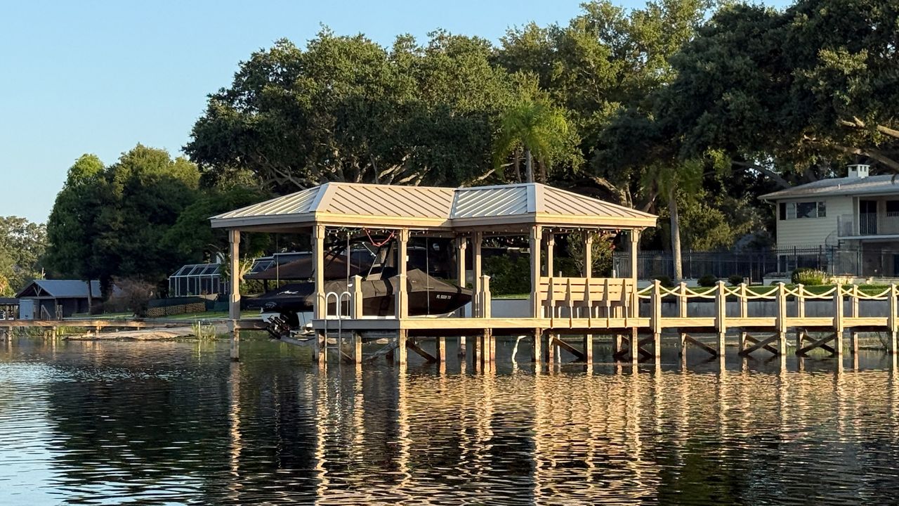 A covered boat dock is built along the shoreline of Little Conway Lake in Orange County.  The county is considering a plan to increase fees to build new docks and boat ramps. (Spectrum News)