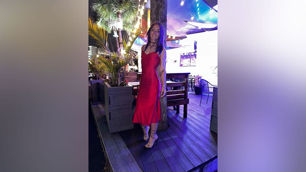 Brittany Clark posing outdoors in a red dress in an undated photo