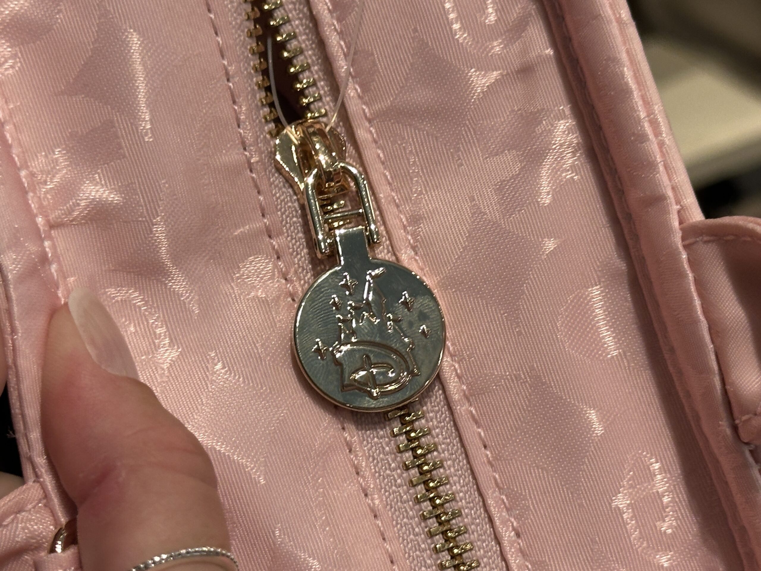 The zipper pull is silver-toned with a Disney