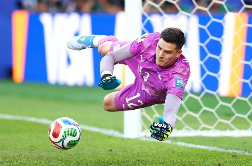Gill dives to stop the fourth penalty kick from Germany in the shootout.
