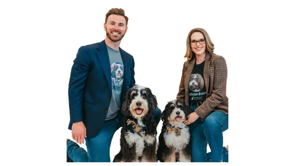 Scholar founder and CEO Ed Buckley poses with a colleague and two therapy dogs used in the company's AI education platform branding.