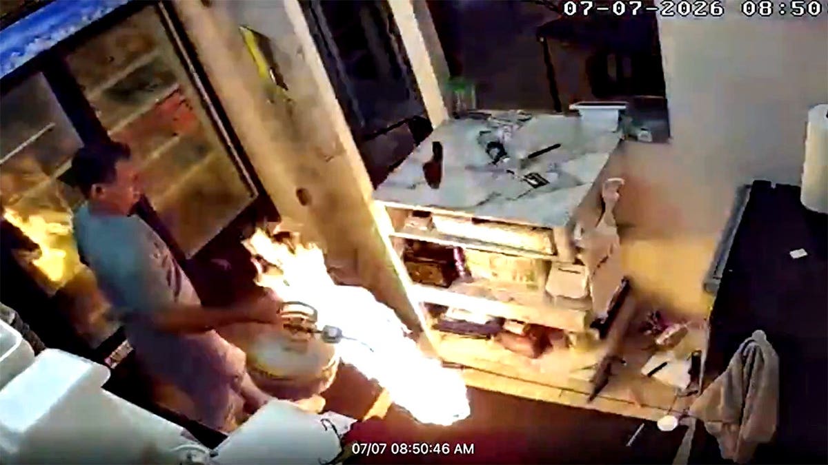 Man carrying flaming propane tank inside restaurant