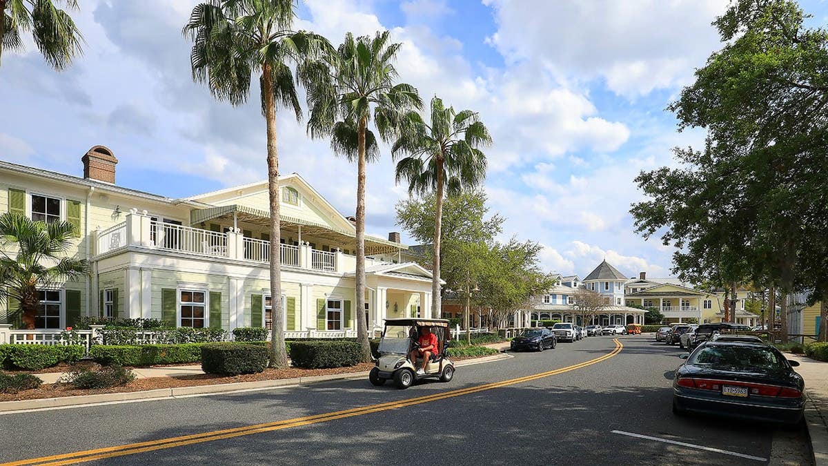 Resident drives a golf cart down main street in The Villages.