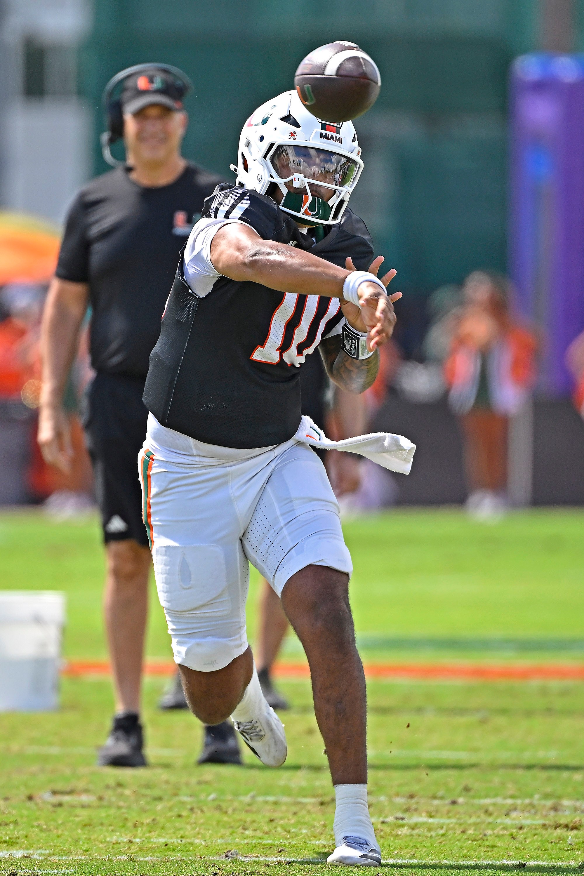 CORAL GABLES, FL - APRIL 18: Miami quarterback Darian Mensah (10) throws a pass with head coach Mario Cristobal watching from the background as the Miami Hurricanes played their spring game on April 18, 2026, at Cobb Stadium in Coral Gables, Florida. (Photo by Samuel Lewis/Icon Sportswire via Getty Images)