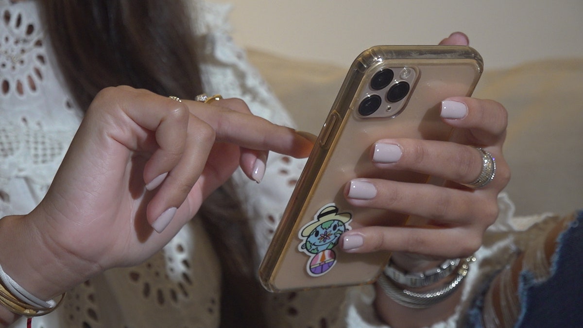 A girl holds a smartphone.