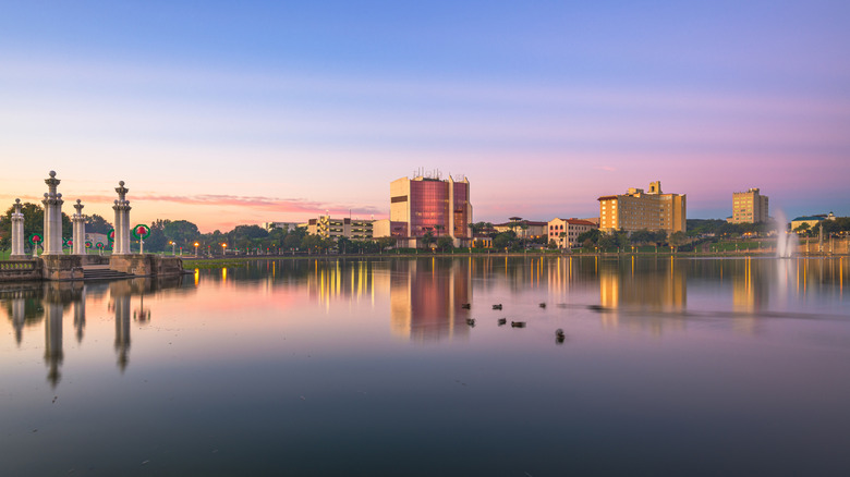 Buildings reflected on water of Lake Mirror at sunrise downtown Lakeland, Florida