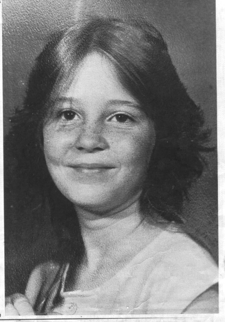 Black and white photo of Teresa Mae McAbee, a young girl with long, dark hair, smiling faintly.