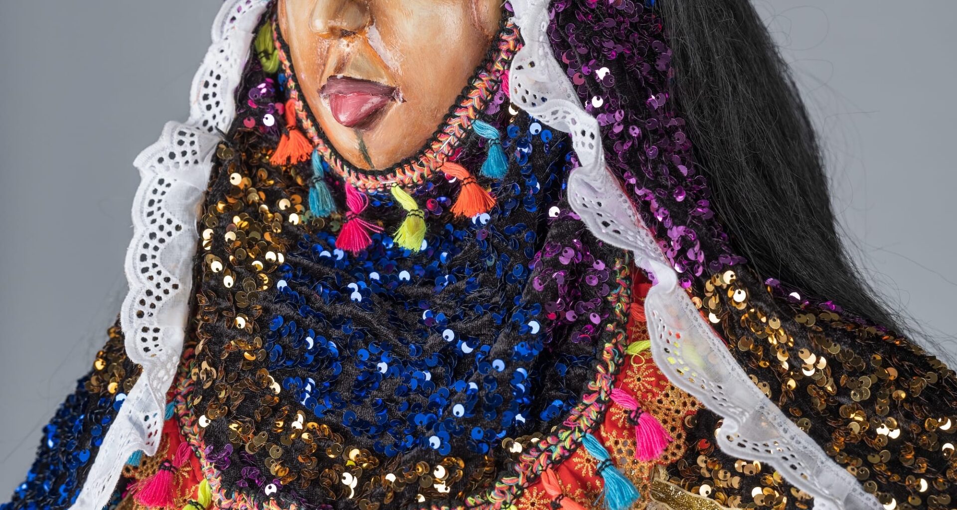 a detail of an elaborate and colorful African masquerade ensemble