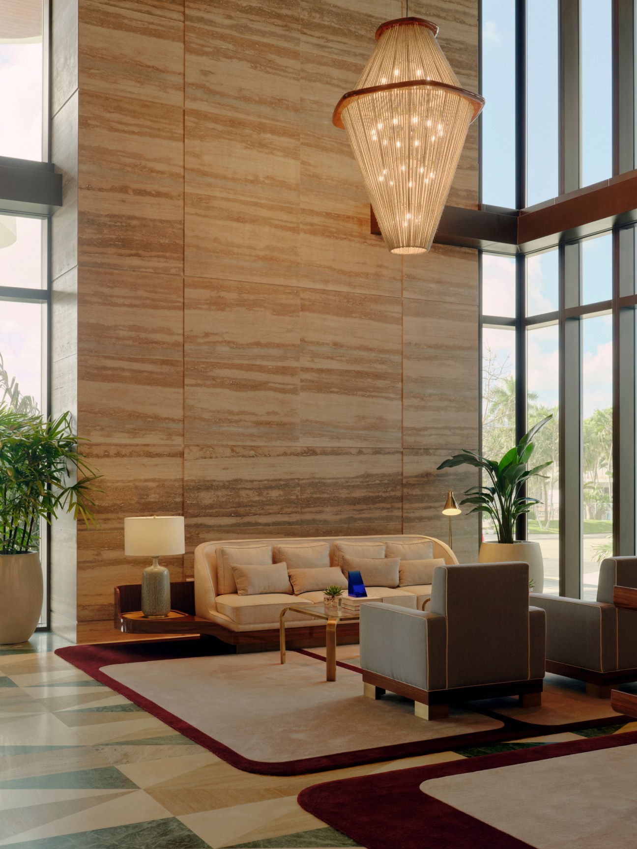 Mid-century modern furniture arrangement in Four Seasons hotel lobby with chandelier and floor-to-ceiling windows